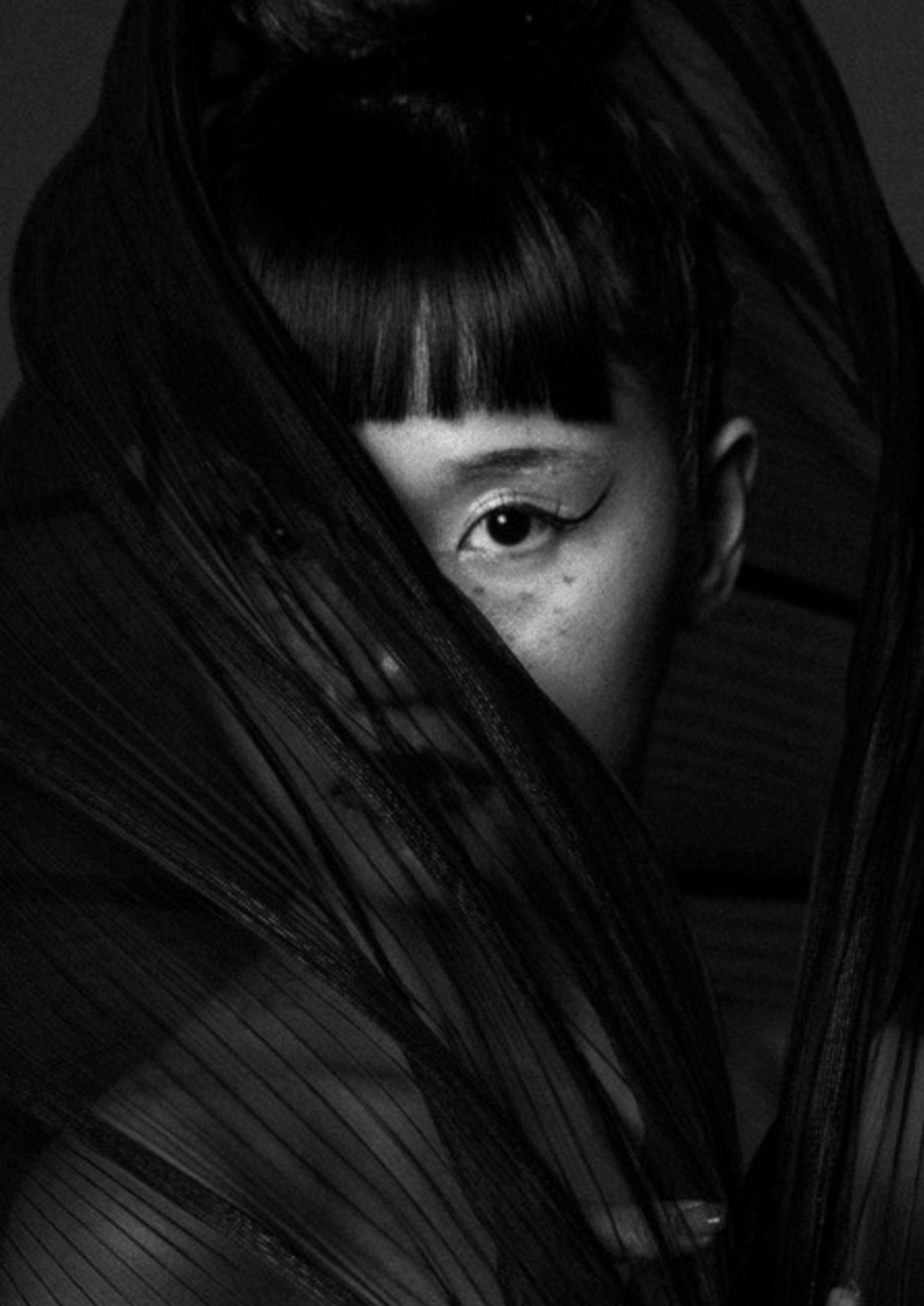Portrait wrapped in pleated black fabric